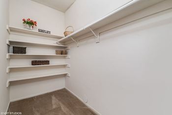 A white shelving unit with a sign that says "SIMPLIFY" and a basket on the top shelf.